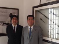 マハトマ・ガンジーの遺品を背に、安倍晋三元総理と。（平成23年9月　ガンジースミリティ博物館）